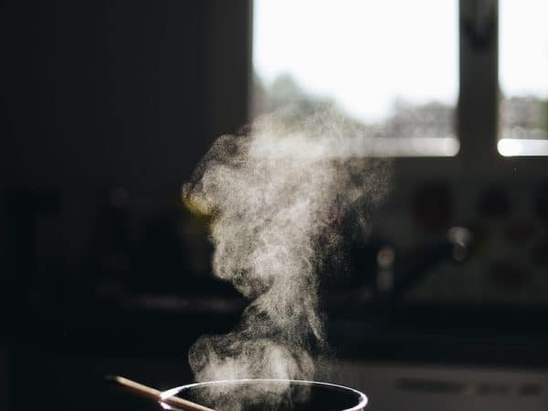 white casserole with gray spoon on black surface